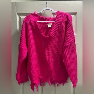 Bright pink sweater with fringe details